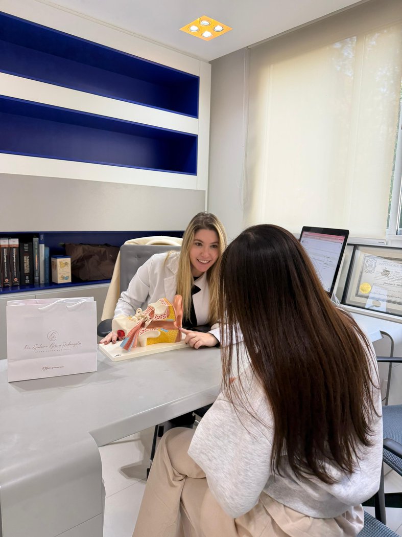 Consulta com modelo anatômico do ouvido